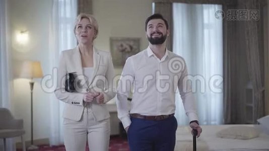 兴奋的白种人夫妇在豪华的酒店房间里环顾四周，朝不同的方向离去的画像视频