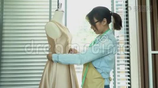 亚洲女性时装设计师测量尺寸的人体模型在展厅。 服装制作和时尚的概念视频
