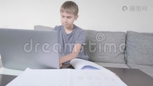 男孩用笔记本电脑学习，在家做作业。 技术、远程教育、在家在线学习视频