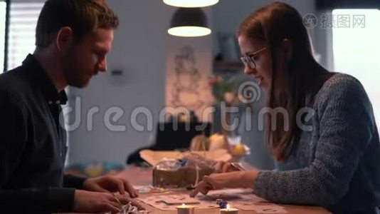 快乐快乐的欧洲男人和女人玩分享问题棋盘游戏在舒适的家一起慢动作。视频