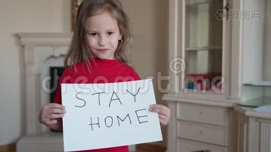 呆在家里的概念。 小女孩穿着红色T恤，手里拿着牌子，说呆在家里保护病毒，照顾她视频