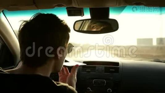 开车的人在开车时使用电话。 聊天和开车。 电话上的音频信息视频