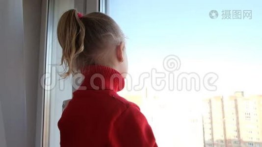 可怜的小女孩望着窗外。 呆在家里隔离。 隔离概念。 病毒流行爆发视频