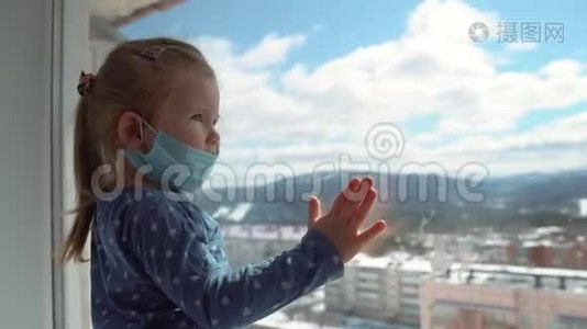 一个戴着医用口罩的小女孩在一次世界性的病毒流行中从窗户往外看。 停止感染、流感及SARS视频