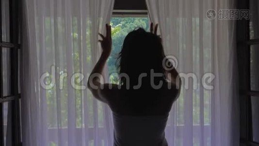 卧室里的女人早上打开窗帘和窗户视频