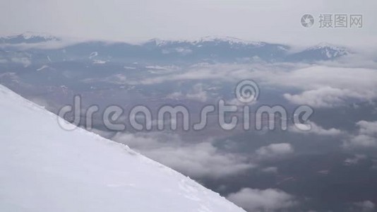 一个旅行者爬上雪山的山坡视频