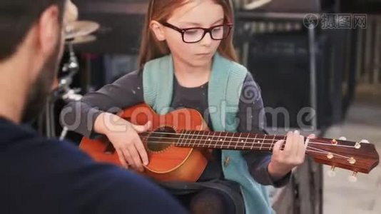 爸爸给女儿教吉他和四弦琴。 小女孩在家学吉他。 快关门。 在家上Ukulele课视频