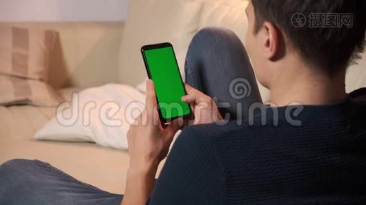 男人手里拿着智能手机，手里拿着绿色屏幕，男人手里拿着带有色度的手机视频