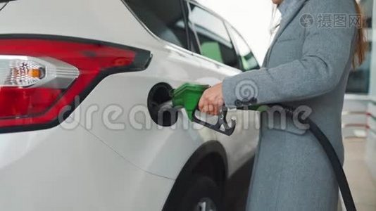 女人在加油站给她的车加满汽油。 慢动作视频