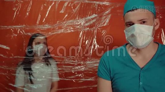 年轻女子戴着医用口罩，被迫与冠状病毒隔离。 前景中戴医用面罩的男医生把他隔离了视频