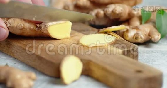 男人`手把新鲜的姜切成切片放在木切板上..视频