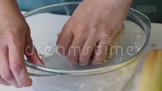 一个女人揉一块面团做新鲜蛋糕。 双手捏在玻璃容器里.. 准备无酵饼视频