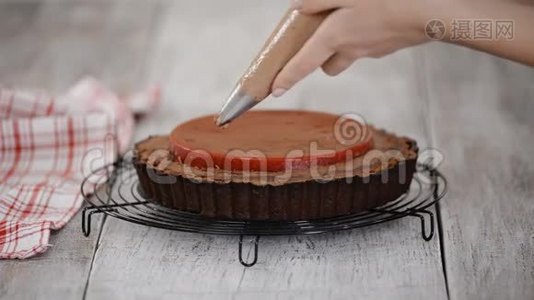糖果师用樱桃糖果和巧克力奶油装饰美味的巧克力馅饼。视频