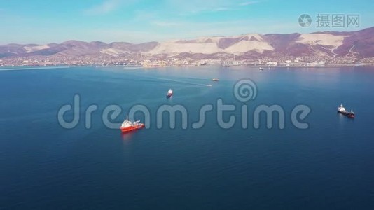 从空中俯瞰，船只在平静的蓝色海面上漂流到丘陵海岸视频
