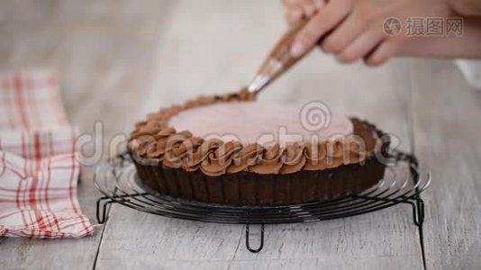 糖果师用樱桃糖果和巧克力奶油装饰美味的巧克力馅饼。视频