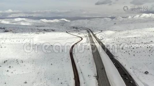 空中无人驾驶飞机，俯瞰交通，被雪峰包围，在冬日视频