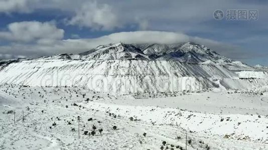 飞越白雪覆盖的白色高海拔山顶斜坡的空中景色视频