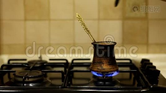 在一个铜土耳其磨黑咖啡，煮在煤气炉上。视频