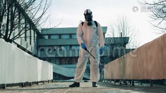 一名穿着防护服的工人正在消毒街道。 冠状病毒，covid-19，2019-ncov概念..视频