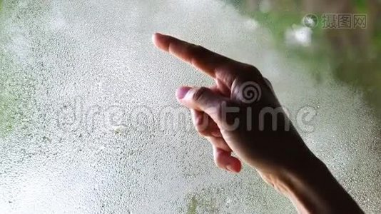 一`女人的手在雾蒙蒙的玻璃上画了一个问号视频