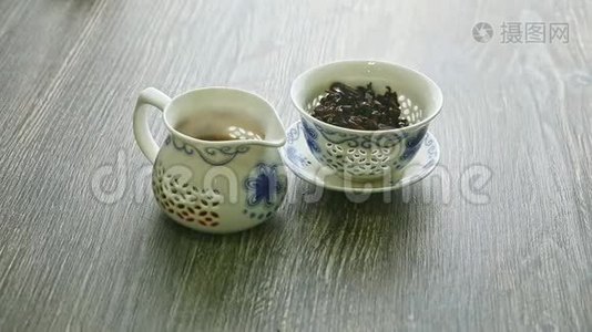 用茶叶和热茶壶装上白色瓷茶壶视频