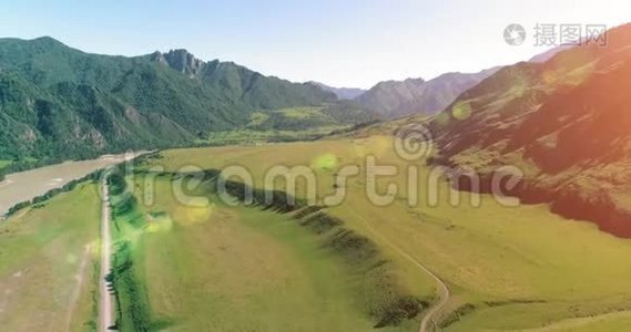 阳光明媚的夏季早晨，空中乡村山路和草地。 沥青公路和河流..视频