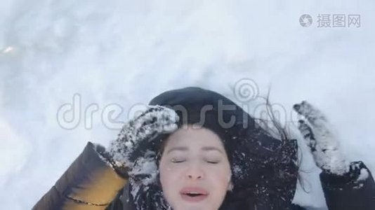 一个女孩躺在雪地里笑的画像视频