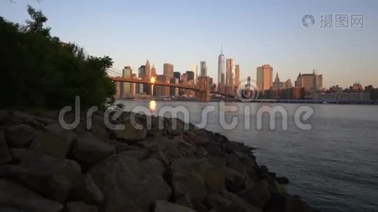 流动景观：曼哈顿市中心景观，靠近水，在美丽的日出阳光下的布鲁克林大桥在夏季水中视频