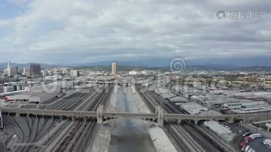 洛杉矶河与水在云层笼罩的天空旁边的火车轨道视频