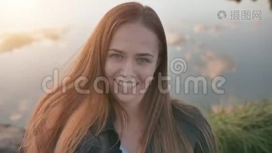 湖背景上一个17岁棕色头发女孩的肖像。视频