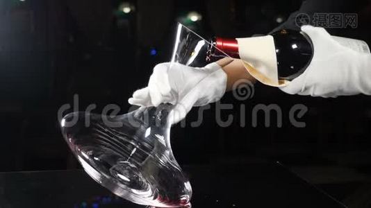 熟练的侍酒师把红酒从瓶子里倒进酒壶。 餐厅的葡萄酒酿造过程，关闭。 手举起来视频
