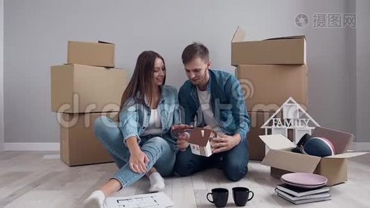 年轻的白种人夫妇在爱规划设计新的家和家具。视频