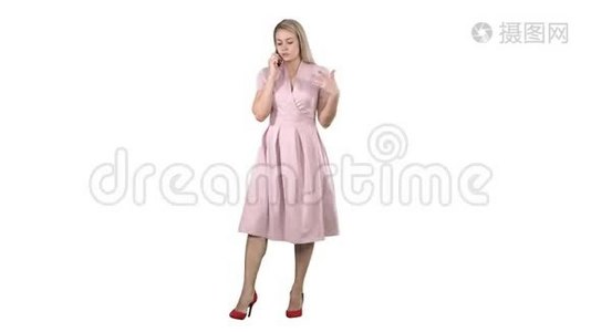 一个穿粉色衣服的漂亮女人在电话里讲话，在白色背景上认真地交谈。视频