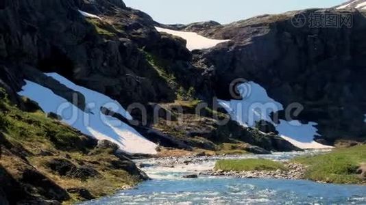 在一个阳光明媚的日子里，挪威高山上积雪融化，河水迅速流淌。 夹子右侧的热片。视频