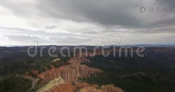 在阴天，无人机摄像机在一片黑松林的峡谷和高速公路上移动视频