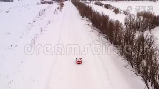 一辆车正沿着一条冬天下雪的乡村道路行驶。 从无人驾驶飞机上俯瞰。视频