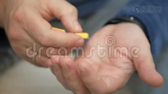 男人用手从水泡包里拿药丸。 特写男性手倒白橙圆片.. 手里拿着药剂丸。 氟视频