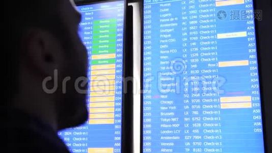 乘客看着时间表屏幕板，用手指指着寻找正确的航班。视频
