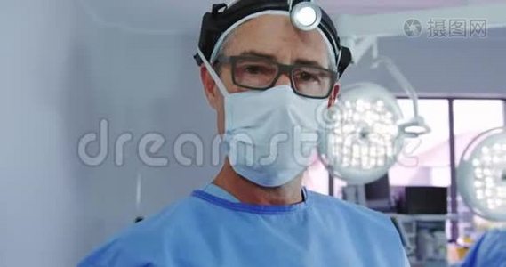 高加索男医生在医院手术室站在手术前照灯中的特写镜头视频