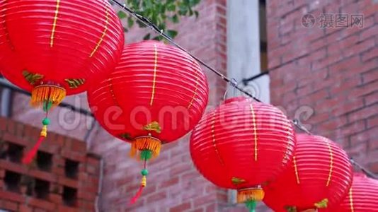 美丽的圆形红灯笼挂在古老的传统街道上，中国农历新年的概念，特写。 下面视频