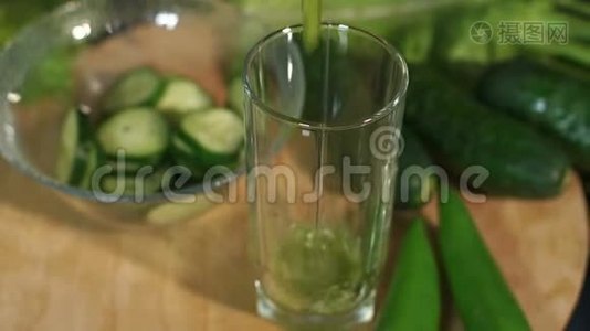 一个女人的特写镜头在黑色背景下的杯子里倒入一杯绿色的新鲜鸡尾酒视频