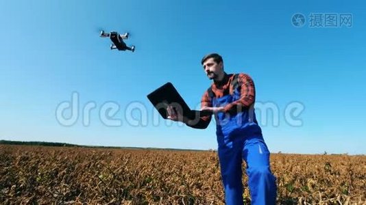 农场工人在田里控制一架无人机。视频