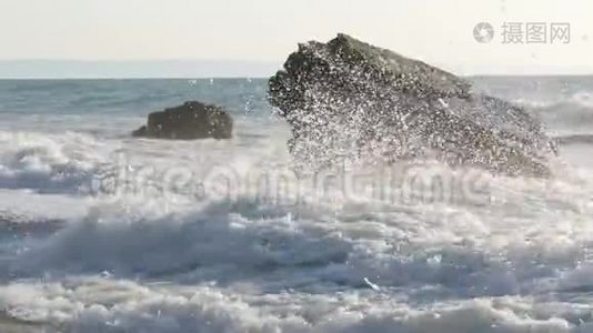 海上日出或日落。 美丽的暴风雨波浪，泡沫覆盖着海岸上巨大的岩石和巨石视频
