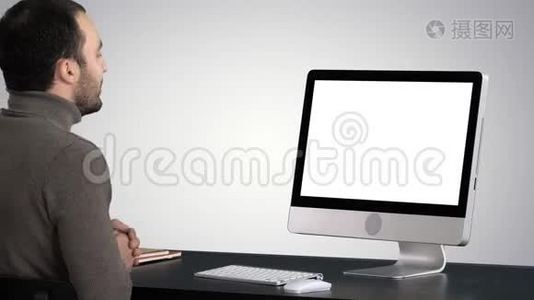 年轻的商人在梯度背景下对他的电脑进行视频通话。视频