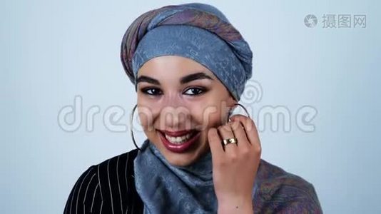 年轻美丽的阿拉伯女人笑着，她的手靠近她的脸在孤立的白色背景视频