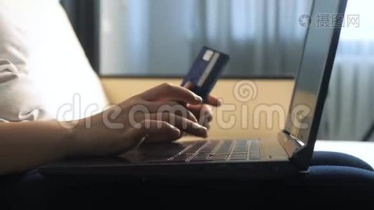 女孩用数字平板电脑制作网上销售购物概念。 黑发女人躺在沙发上看着网上支付的商店视频