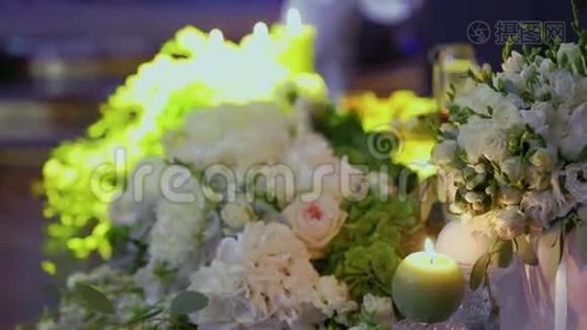 婚礼装饰，玻璃瓶中的蜡烛。 烛台上的婚礼蜡烛。 白色玫瑰婚礼装饰视频