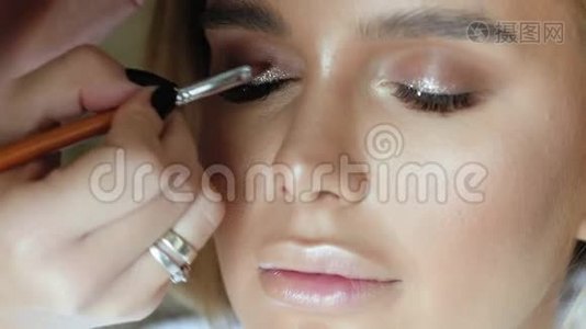 化妆师用一个年轻漂亮的女人做化妆睫毛视频