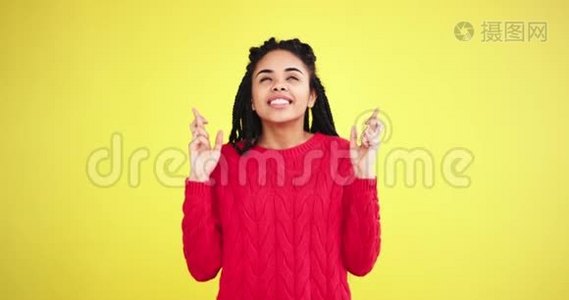 漂亮的非洲年轻女士在一间画室里，黄色的背景墙交叉着手指，祈祷着什么视频