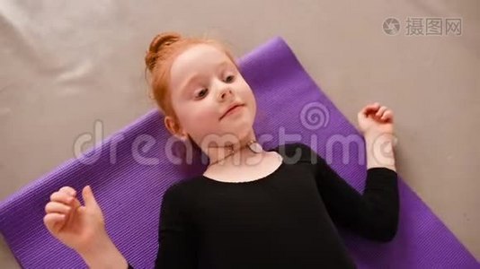 小可爱的红发女孩芭蕾舞演员在芭蕾舞学校的背景下表演伸展运动视频